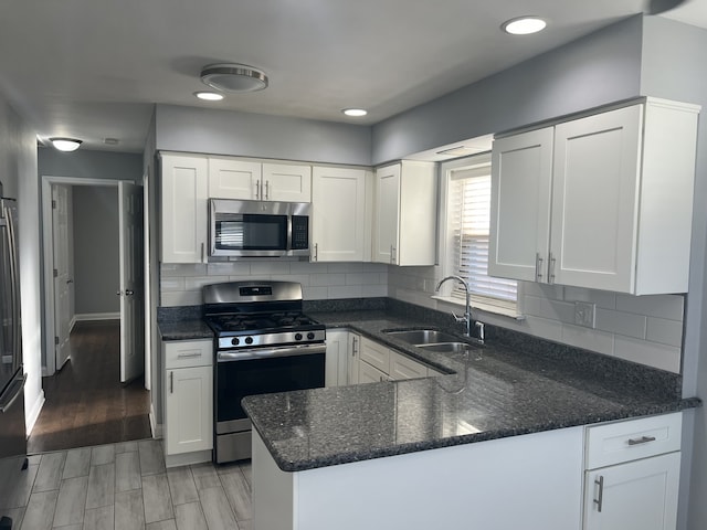 kitchen with light hardwood / wood-style flooring, stainless steel appliances, white cabinetry, and sink