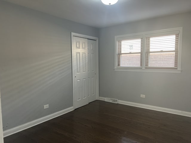 spare room with dark hardwood / wood-style flooring