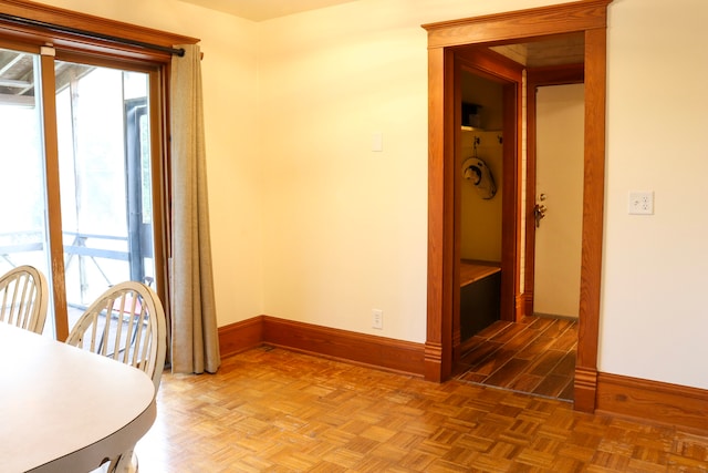 unfurnished dining area with dark parquet flooring