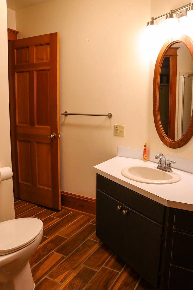 bathroom with vanity, toilet, and wood-type flooring