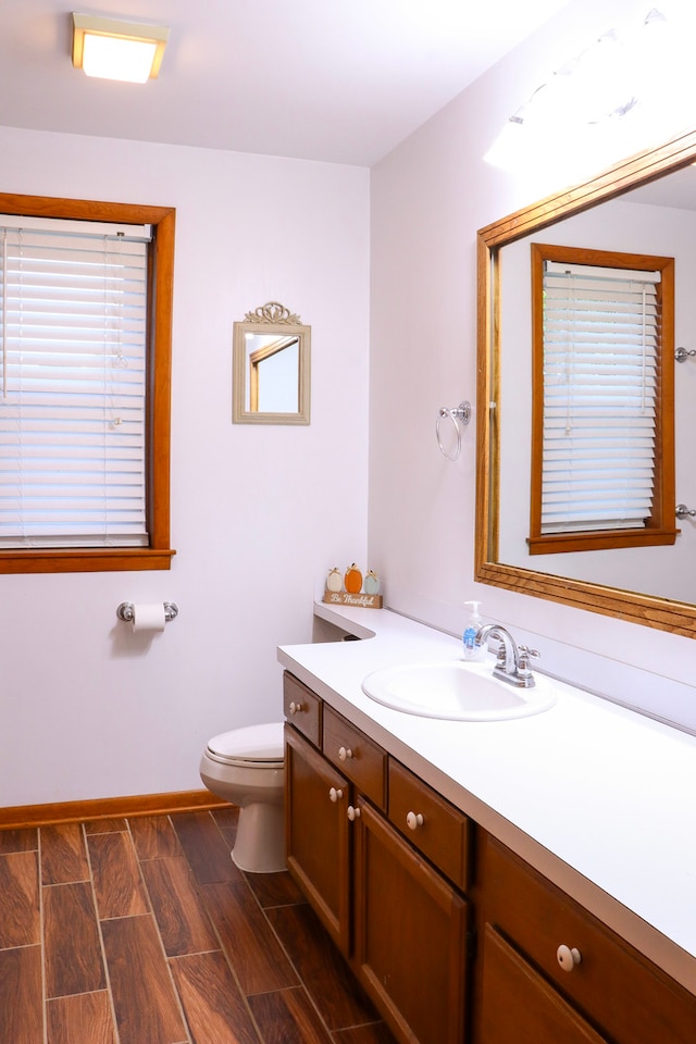 bathroom with hardwood / wood-style floors, vanity, and toilet