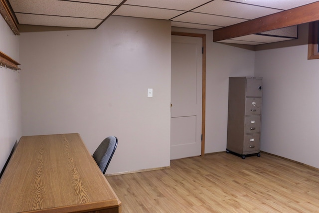 unfurnished office featuring a paneled ceiling and light hardwood / wood-style flooring