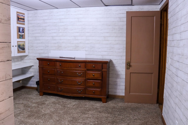 carpeted bedroom with wood walls and a drop ceiling