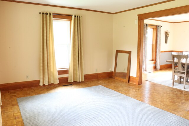 unfurnished room with ornamental molding and light parquet flooring