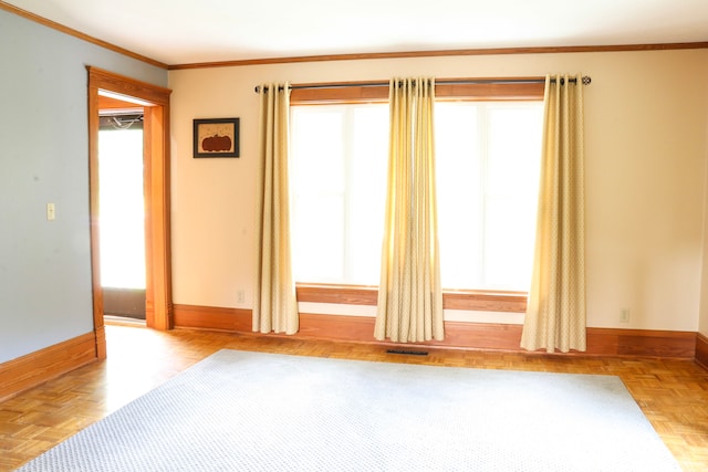 empty room featuring ornamental molding and light parquet flooring