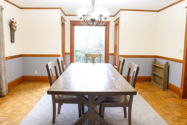 dining space with an inviting chandelier, crown molding, and light parquet flooring