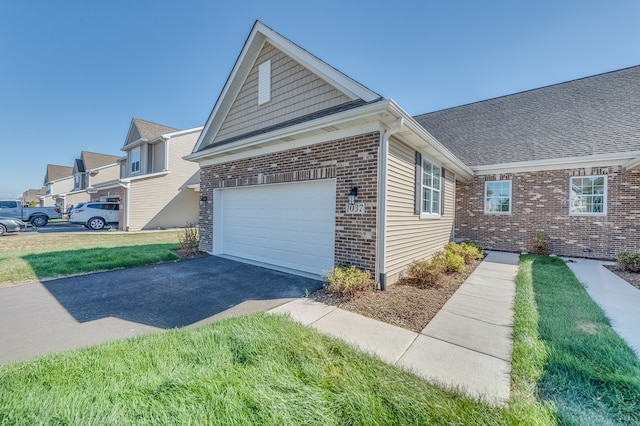 view of side of home featuring a garage and a lawn