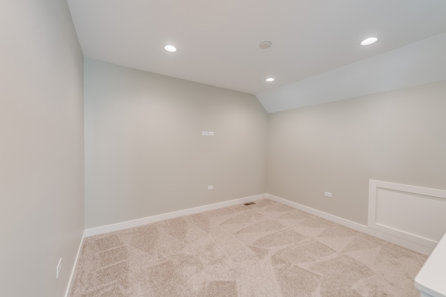 carpeted spare room featuring lofted ceiling