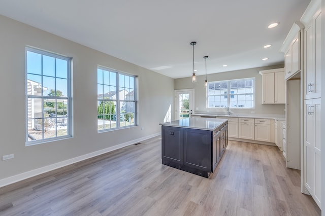 kitchen with plenty of natural light, a center island, and white cabinets