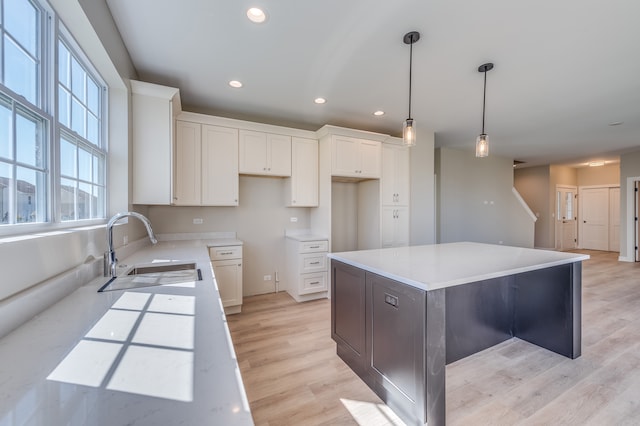 kitchen with light hardwood / wood-style flooring, white cabinetry, and a kitchen island