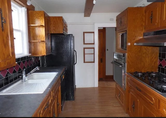 kitchen featuring black appliances, plenty of natural light, hardwood / wood-style floors, and tasteful backsplash