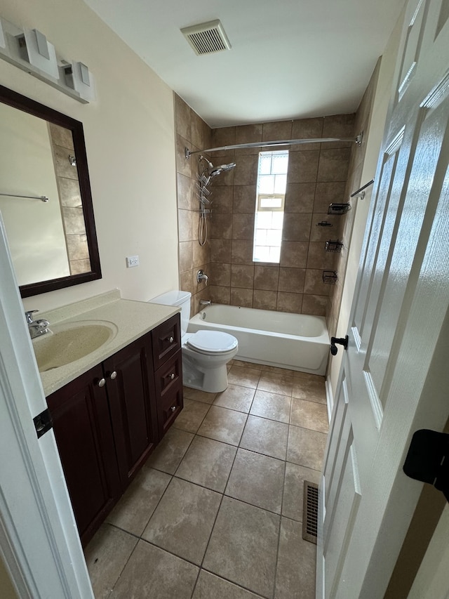 full bathroom with tiled shower / bath combo, tile patterned floors, vanity, and toilet