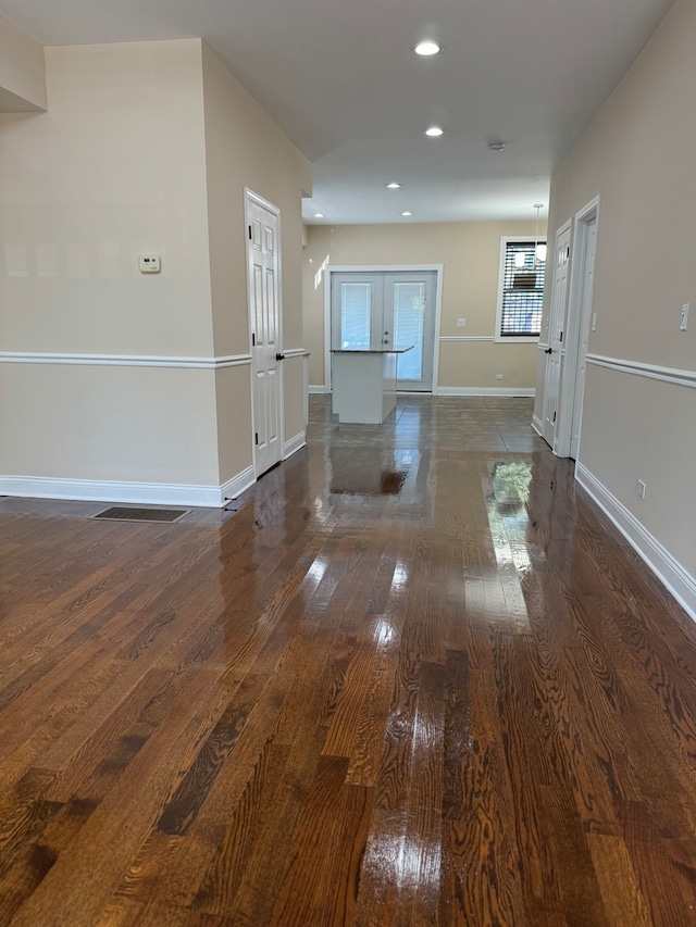 unfurnished living room featuring dark wood-type flooring and french doors