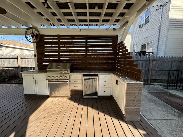 wooden terrace featuring exterior kitchen and a grill