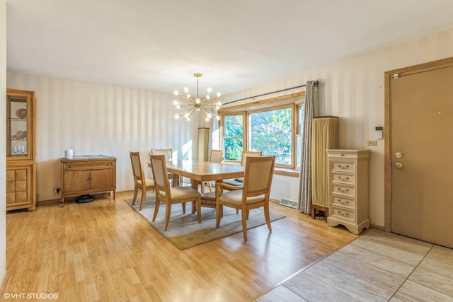 dining space featuring a notable chandelier and light hardwood / wood-style floors