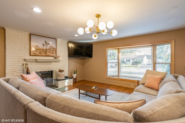 living room featuring a fireplace, an inviting chandelier, and light hardwood / wood-style flooring