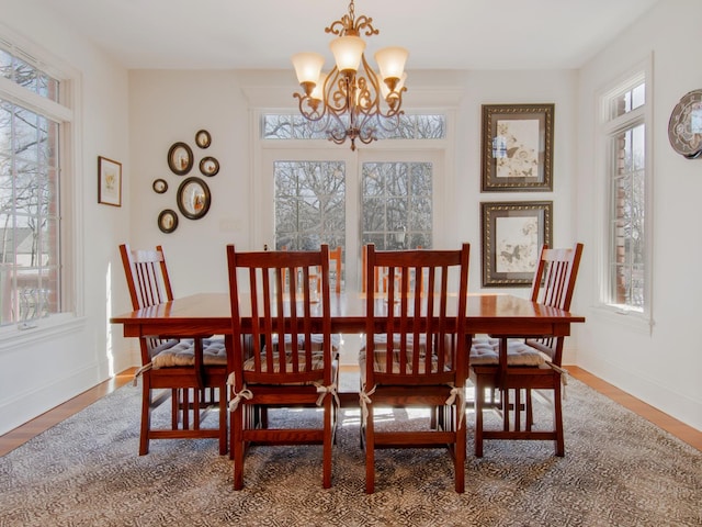 dining area with an inviting chandelier, plenty of natural light, and hardwood / wood-style floors