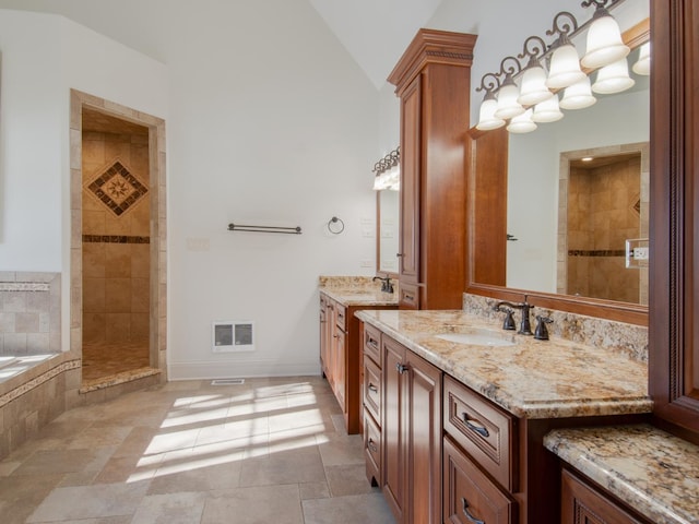 bathroom featuring vanity, vaulted ceiling, and independent shower and bath