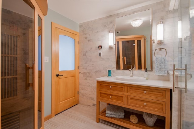 bathroom featuring vanity, an enclosed shower, and tile walls