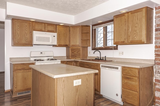 kitchen with a center island, sink, dark hardwood / wood-style floors, a textured ceiling, and white appliances