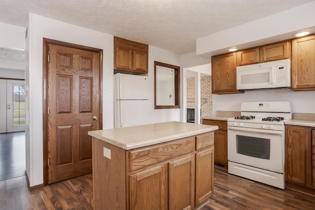 kitchen with dark hardwood / wood-style flooring, white appliances, a textured ceiling, and a kitchen island