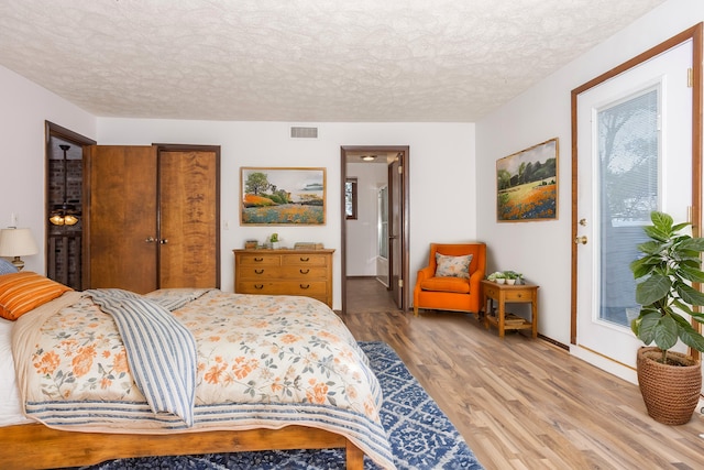 bedroom with a textured ceiling and hardwood / wood-style flooring