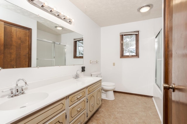 full bathroom with vanity, a textured ceiling, toilet, and combined bath / shower with glass door