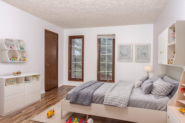 bedroom with a textured ceiling and hardwood / wood-style flooring