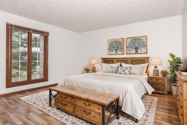 bedroom featuring hardwood / wood-style floors and a textured ceiling