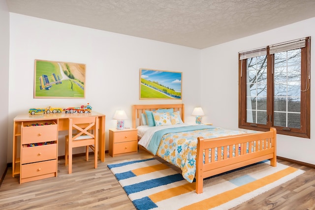 bedroom with hardwood / wood-style floors and a textured ceiling