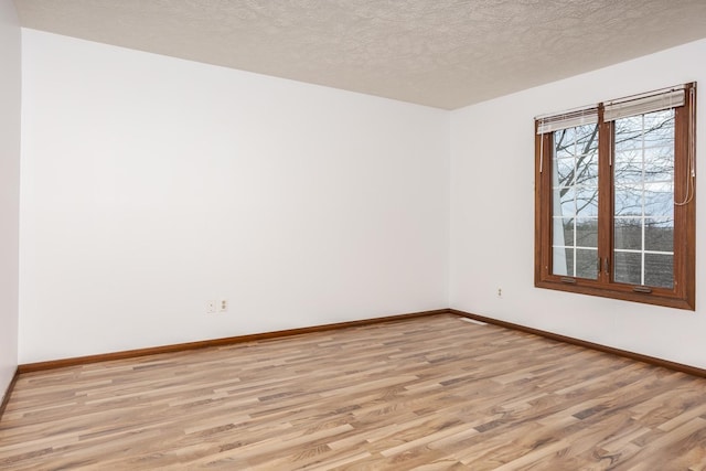 empty room featuring light hardwood / wood-style flooring and a textured ceiling