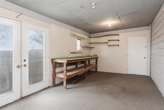 basement featuring french doors and carpet