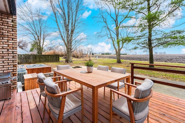 wooden terrace featuring a rural view and a hot tub