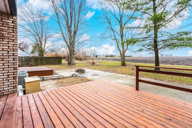 wooden deck with a rural view and an outdoor fire pit