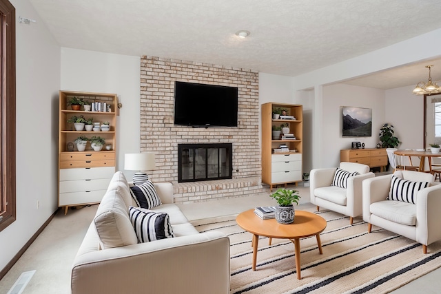 carpeted living room with a fireplace, a textured ceiling, and an inviting chandelier