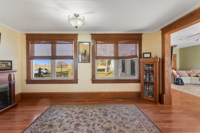 living room featuring hardwood / wood-style floors, crown molding, and ceiling fan