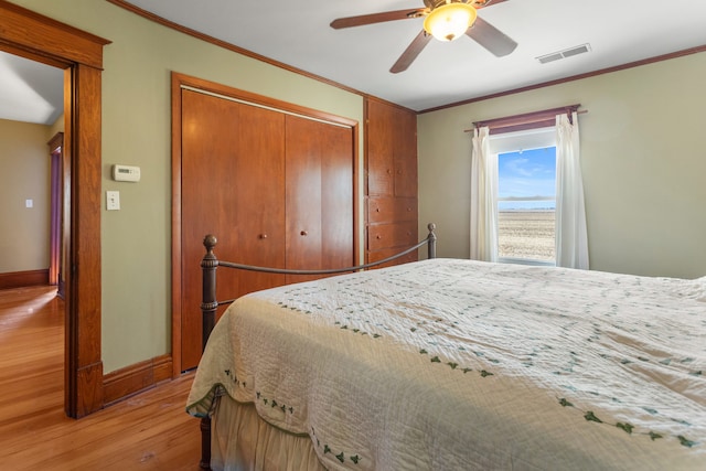 bedroom with ornamental molding, light hardwood / wood-style flooring, and ceiling fan