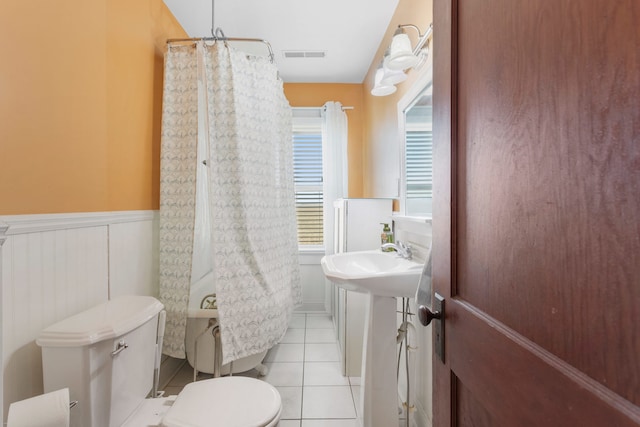 bathroom featuring toilet, tile patterned floors, sink, and plenty of natural light