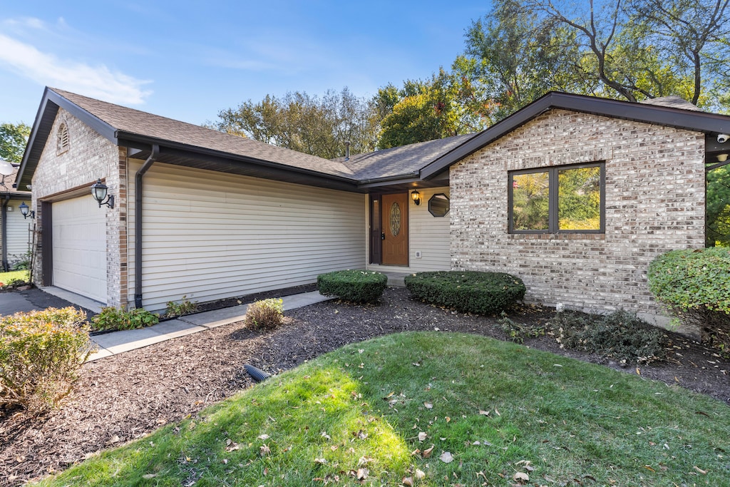 ranch-style home featuring a front yard and a garage