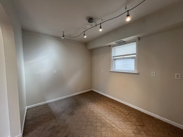 spare room with carpet and track lighting