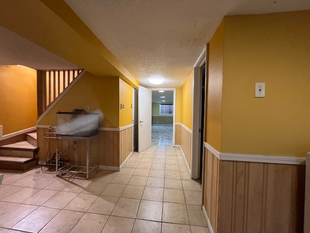 hall with light tile patterned floors and a textured ceiling