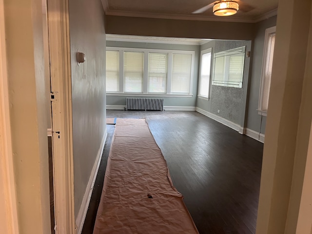 unfurnished room featuring crown molding, radiator, and dark hardwood / wood-style flooring