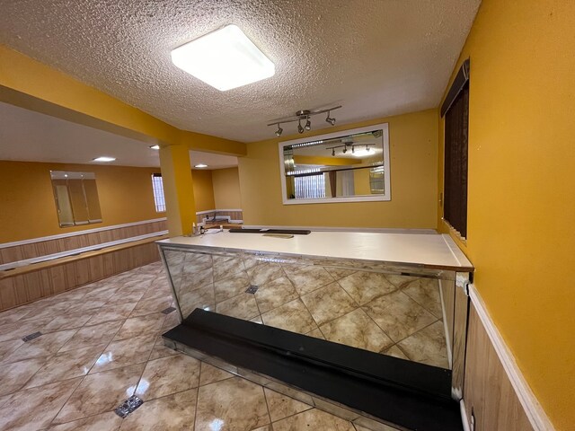 workout room with tile patterned flooring and a textured ceiling