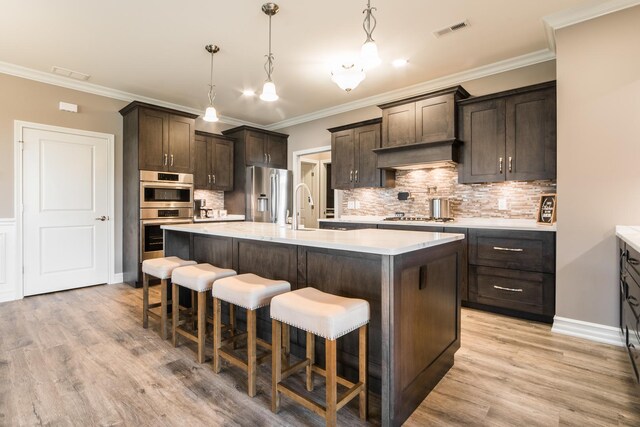 506 Stearn Dr Unit 506, Genoa, IL 60135 - kitchen featuring stainless steel appliances, a kitchen bar, dark brown cabinets, light countertops, and a center island with sink