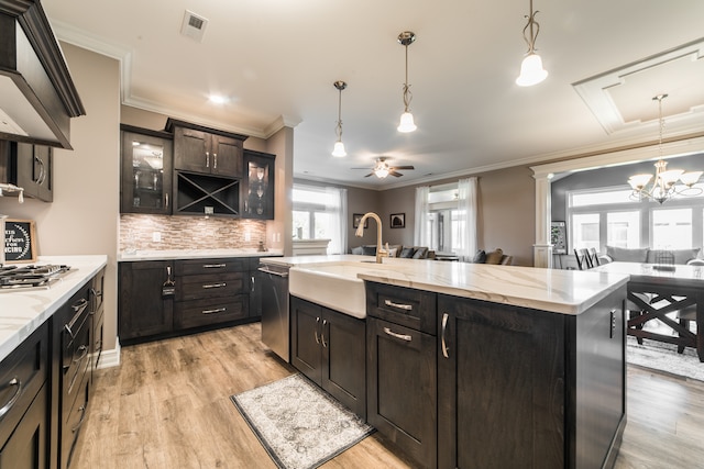 kitchen featuring a center island with sink, appliances with stainless steel finishes, pendant lighting, light hardwood / wood-style floors, and sink