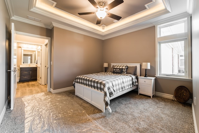 carpeted bedroom featuring sink, crown molding, a tray ceiling, and ceiling fan