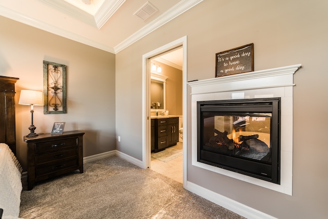 carpeted bedroom with ornamental molding, a multi sided fireplace, and ensuite bathroom