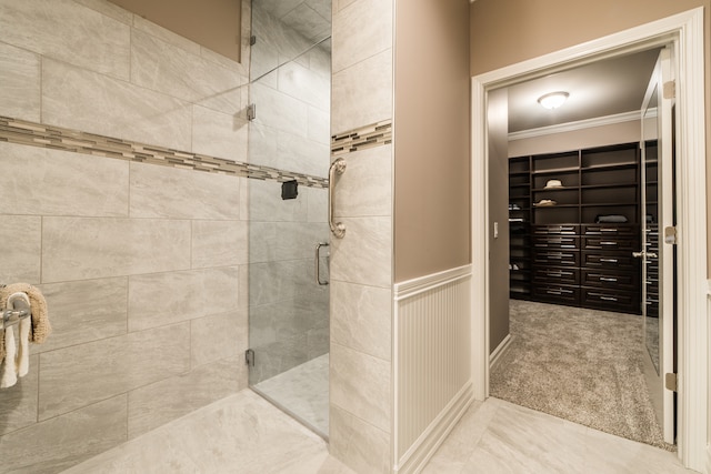 bathroom with ornamental molding and an enclosed shower