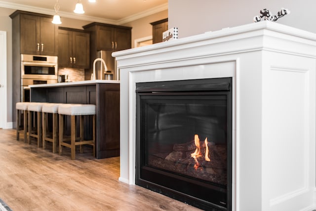 details featuring crown molding, double oven, and hardwood / wood-style floors