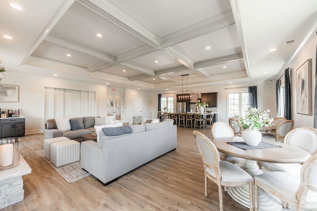 living room with beamed ceiling, coffered ceiling, and light hardwood / wood-style floors